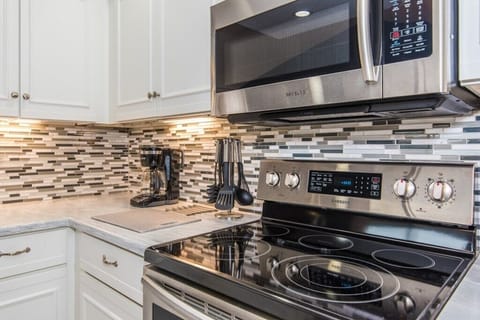 Modern kitchen with sleek appliances and stylish backsplash.