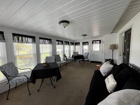 Sunroom with 2 tables, 6 chairs, and futon.