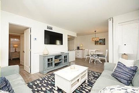 Your spacious open-plan living area blends comfort with coastal style, featuring plush seating and a dining space perfect for memorable meals.