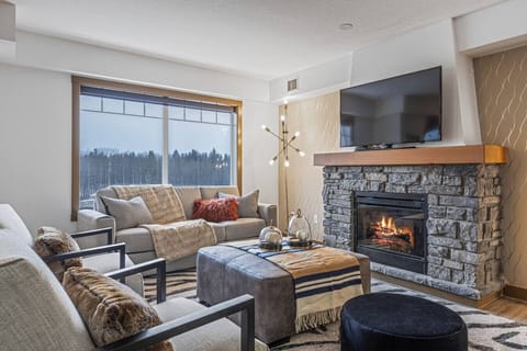 Relax by the fireplace in the living room area while watching your favorite movie.