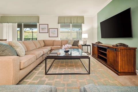 Relax in this spacious living room with a plush sectional and large TV, perfect for entertaining or unwinding after a day of adventure.