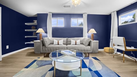 Living space, featuring vibrant navy walls, modern furnishings.