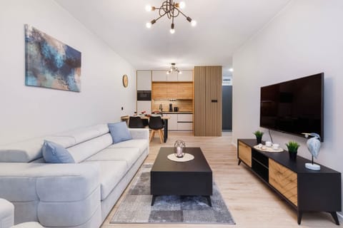 A cozy living room with a modern sofa, coffee table, and warm lighting.
