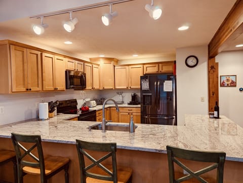 Open kitchen with breakfast bar, fully equipped with new appliances and a Nespresso machine.