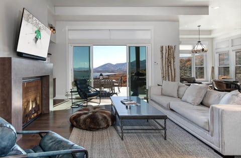 Unwind in your spacious living room where a cozy fireplace meets breathtaking mountain views. Sink into plush seating, enjoy your favorite shows, and step onto your private balcony to soak in the serene landscape.