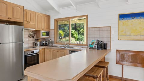 he rustic, white-wall theme continues in the fully equipped kitchen. The wooden countertops and cabinets have a clean and charming appeal