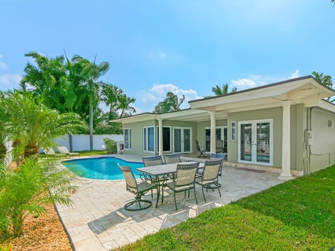 Private backyard offers a crystal blue swimming pool and seating area.