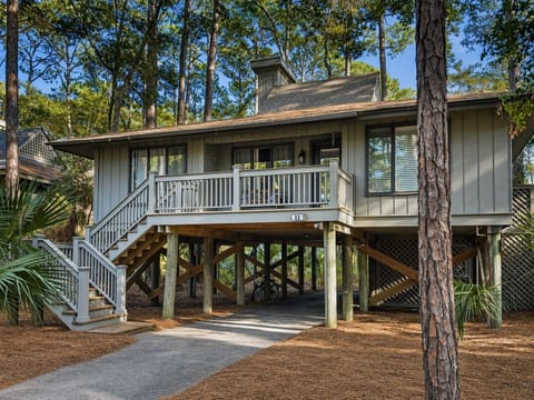 Cozy beach cottage featuring covered parking and a welcoming front deck in a peaceful coastal setting.