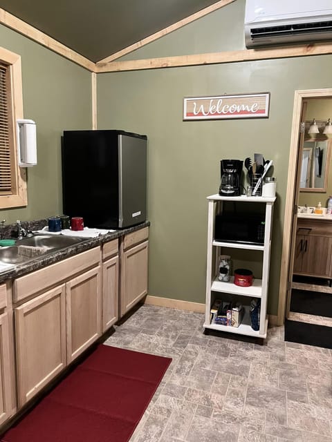 Kitchen includes coffee pot, griddle, microwave, and medium sized refrigerator 