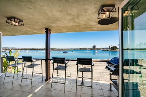 Spacious upper-level private outdoor balcony with barstools offering bay views and a large Grill for Outdoor Dining.