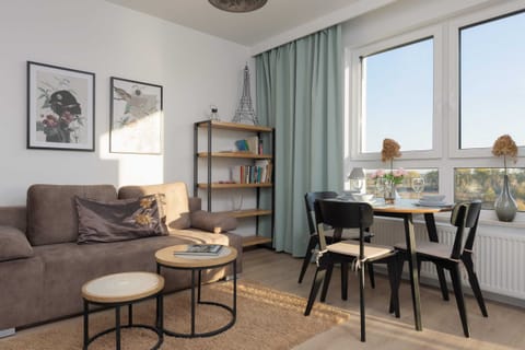 A cozy living space featuring a comfortable sofa, coffee table, and a TV unit with large windows leading to the balcony.

