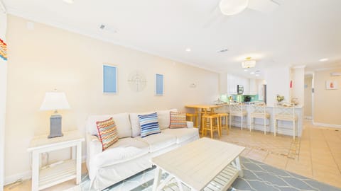 Your bright, open living space features coastal charm with comfortable seating and colorful pillows, perfect for relaxing after beach days.
