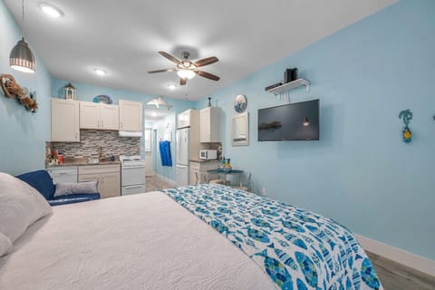 Inviting bedroom w/ TV, ceiling fan, & beach-inspired accents for easy unwinding.