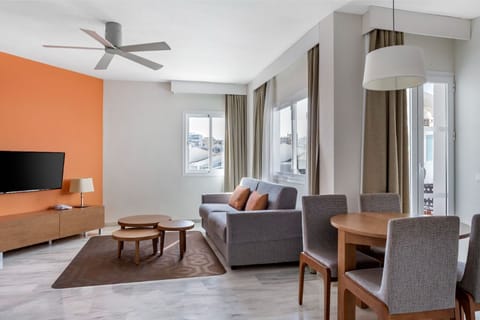 Contemporary living area with plush seating and floor-to-ceiling windows, offering a space filled with natural light.