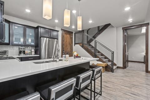 Fully equipped kitchen space features stainless steel Viking appliances, stone countertops, and bar seating for four