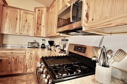Close-up view of this fully equipped kitchen, adorned with beautiful wood cabinets that elegantly house a fitted oven.