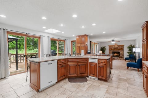 Your gourmet kitchen awaits with granite counters, rich wood cabinetry, and open views to the deck and nature beyond.