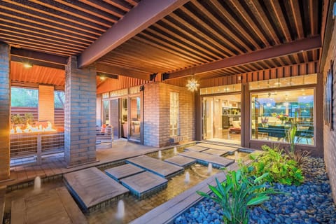 The entrance to this stunning 3,500-square-foot villa features a custom-designed water walkway and an expansive, fully enclosed front yard. Adjacent to the entrance, is a stylish lounge area furnished with premium Sunbrella outdoor furniture!
