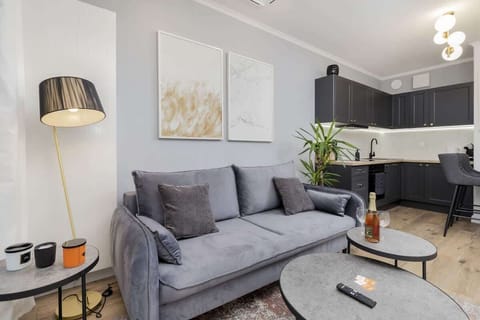 Living room with gray sofa, round coffee table, floor lamp, and modern artwork.
