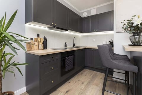 Kitchen with dark cabinets, dining area, and wooden countertop.
