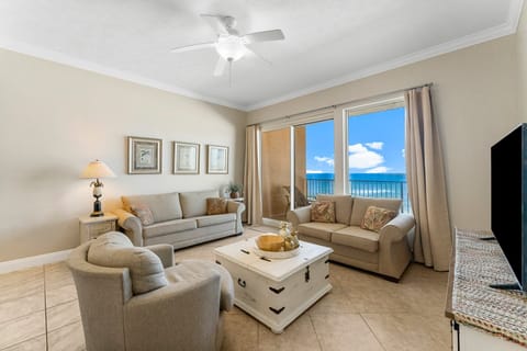 Relax in this bright living room with ocean views through sliding glass doors.
