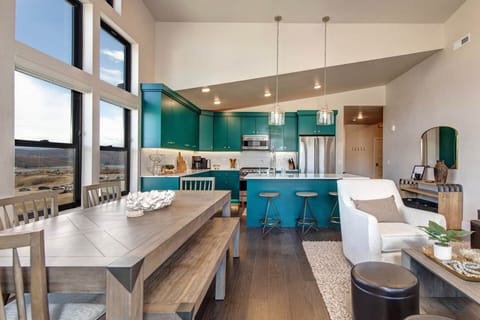 Mayflower Lakeside 1121-304: The space features a modern kitchen with bold, aquamarine-colored cabinetry and an open-concept living and dining area.