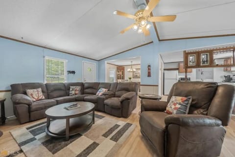Cheerful open living spaces with ample and comfortable seating and ceiling fan.