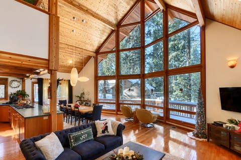 Vaulted ceilings and tall windows fill this open living space with forest views!