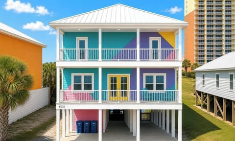 Bold pastel beach house on stilts with double balconies near the shore!