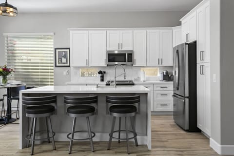 Large Quartz Center Island with Elegant Swivel Bar Stools with comfortable backs