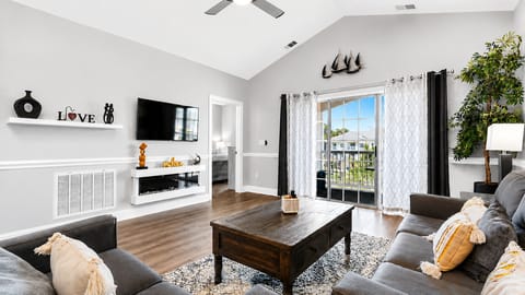 Bright, spacious living room with balcony views and modern coastal décor.