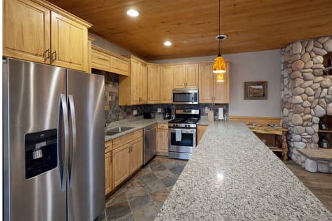 Your fully equipped kitchen features granite countertops, stainless steel appliances, and warm wood cabinetry, perfect for preparing memorable meals together.