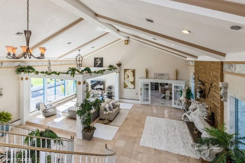 Living room with oversized fireplace, bay views, and double bridal staircase. 
