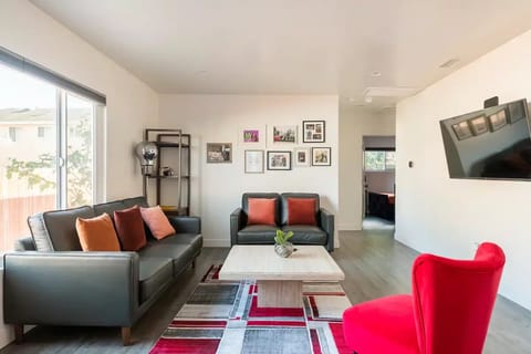 Our Modern Living Room with natural light, comfortable sofas and a 4K 55" TV.