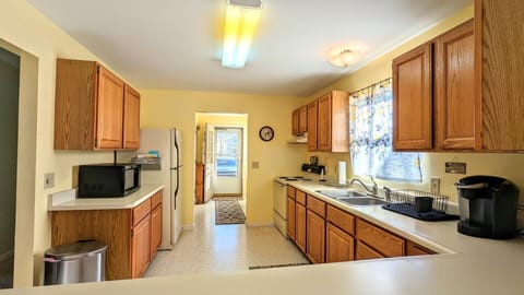 Kitchen area looking into the entry where there is a closet with a washer and dryer