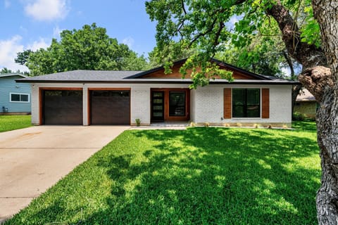Charming modern Austin home with fresh curb appeal, mature trees, and a spacious driveway with double garage — bright, inviting, and ready to welcome you.