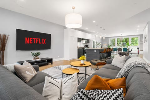 Bright open-plan lounge with Netflix, island seating, and garden views