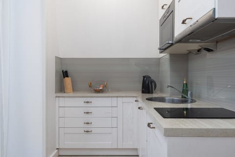 Kitchenette with kettle and refrigerator. 