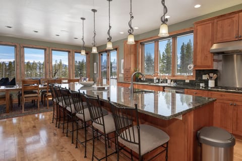 - Prep meals or share drinks at this spacious kitchen island with seating - Pendant lights and wood cabinetry create a warm mountain ambiance - Enjoy panoramic forest views while cooking and entertaining with ease