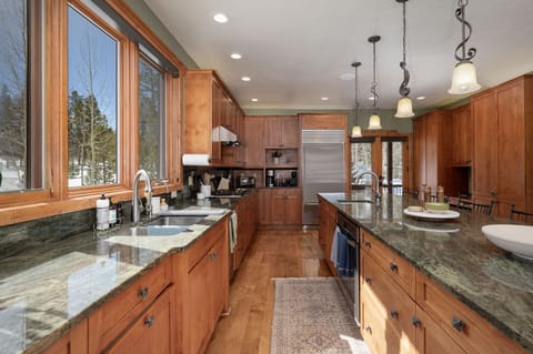 - Cook with ease in this fully equipped kitchen with premium appliances - Plenty of counter space, dual sinks, and storage keep everything organized - Large windows overlook forest views for a scenic meal prep experience