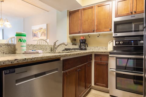 Fully stocked kitchen with stainless steel appliances.