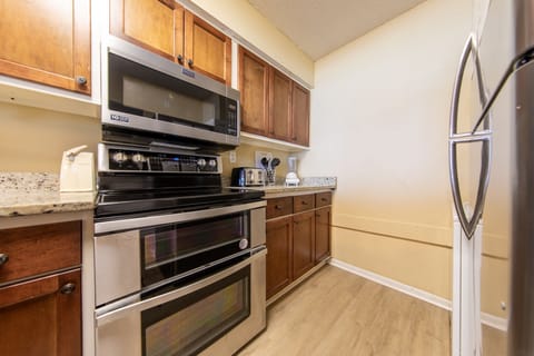 Fully stocked kitchen with stainless steel appliances.