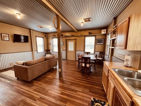 Folks love the rustic look of the main area of the cottage! It's an open floor plan, featuring rich woodwork and a corrugated steel ceiling.