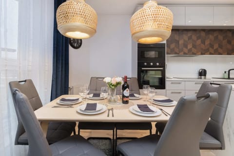 A dining table with modern chairs and elegant lighting, perfect for shared meals.