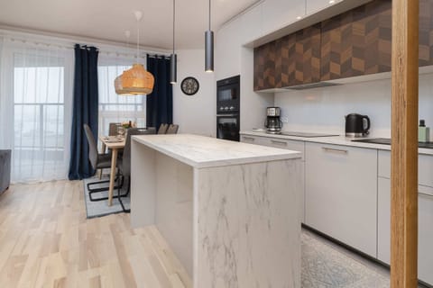 A modern kitchen with wooden cabinets, a sleek island, and all necessary appliances.