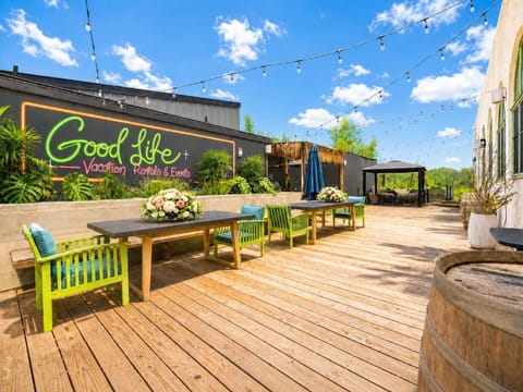 Outdoor Entertaining Deck with String Lights, Dining Tables, and Open Seating — A Bright, Relaxed Space for Dining and Lounging
