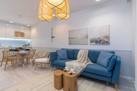 A living room with a cozy blue sofa, a wooden coffee table, and a warm lighting fixture creating a homely ambiance.