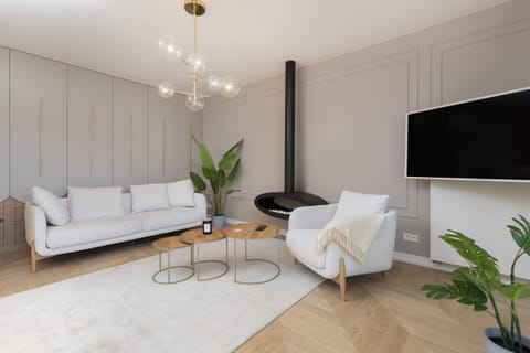 Living room with a white couch, wooden furniture, and a bright and minimalistic design.