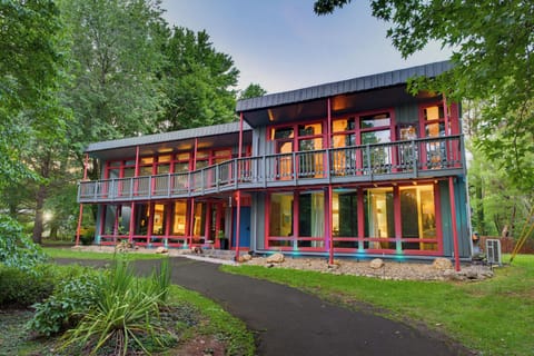 Modern wooded retreat with wall-to-wall windows and a spacious balcony