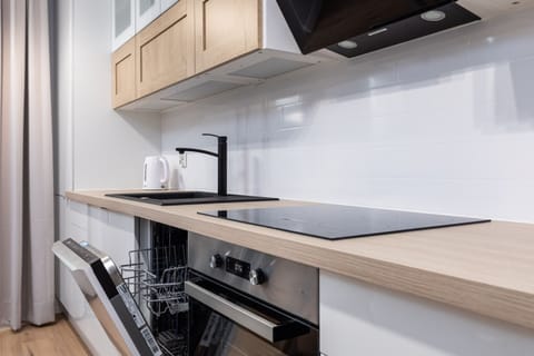A close-up of the kitchen's countertop and stove, highlighting its functionality and clean finish.